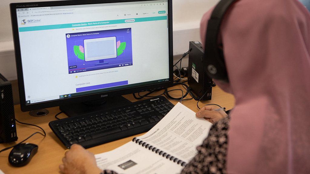 A student with headphones learning at a computer