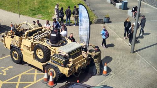 Students looking at an army truck