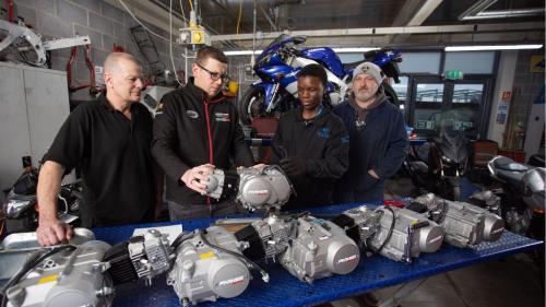 Students and tutors in automotive workshop 